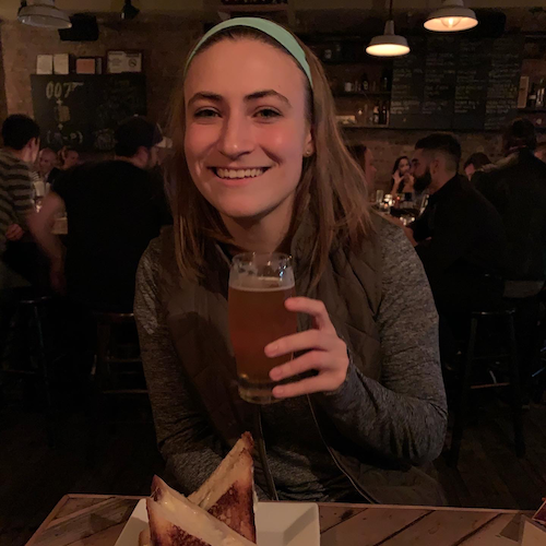 Clara with a pint of beer at a bar.